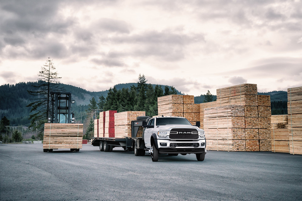 A commercial lease 2025 Ram Chassis Cab pulls a large trailer of wood.